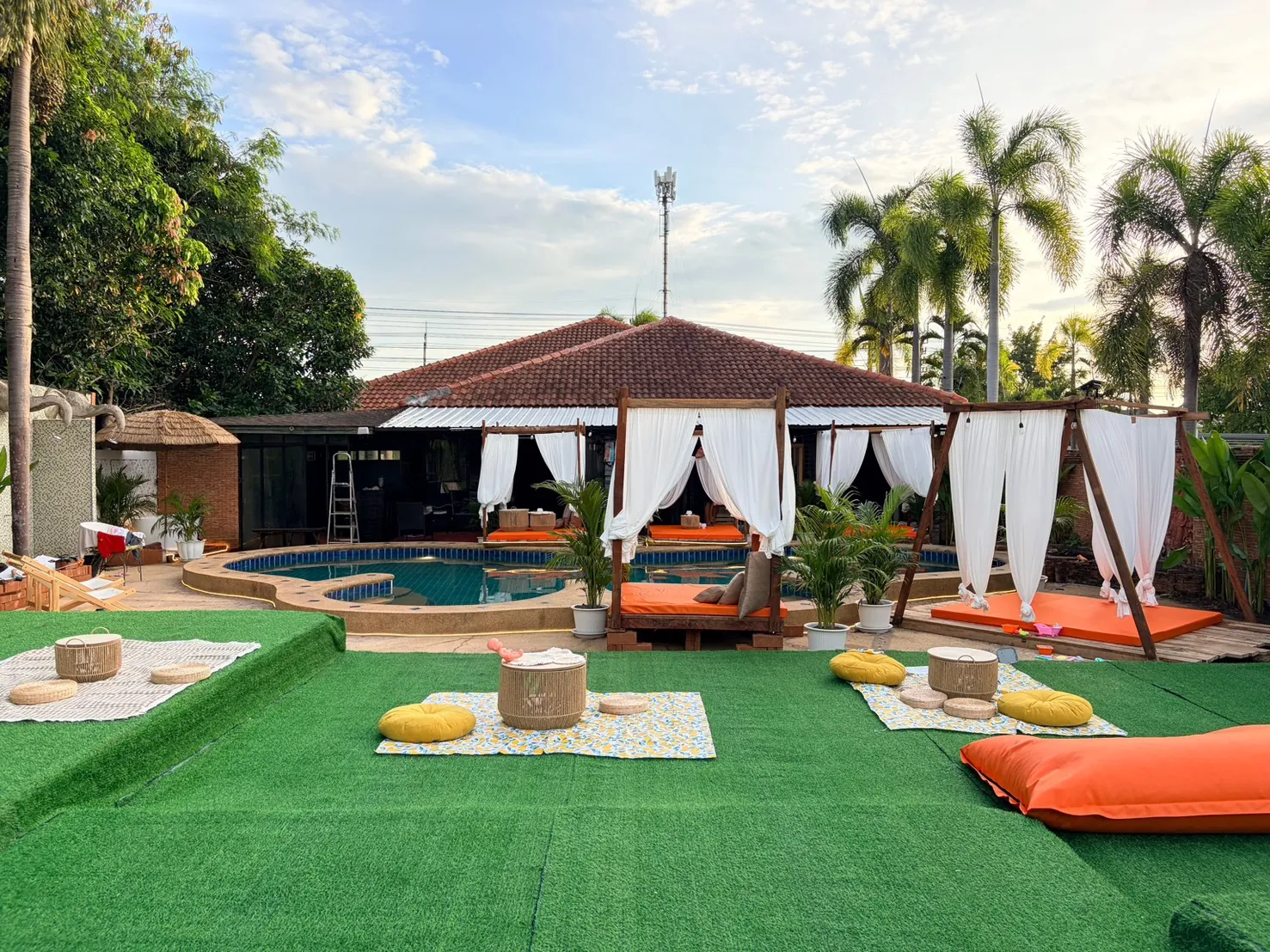 Garden massage area with cushions and Thai-style building at Dewata Pattaya